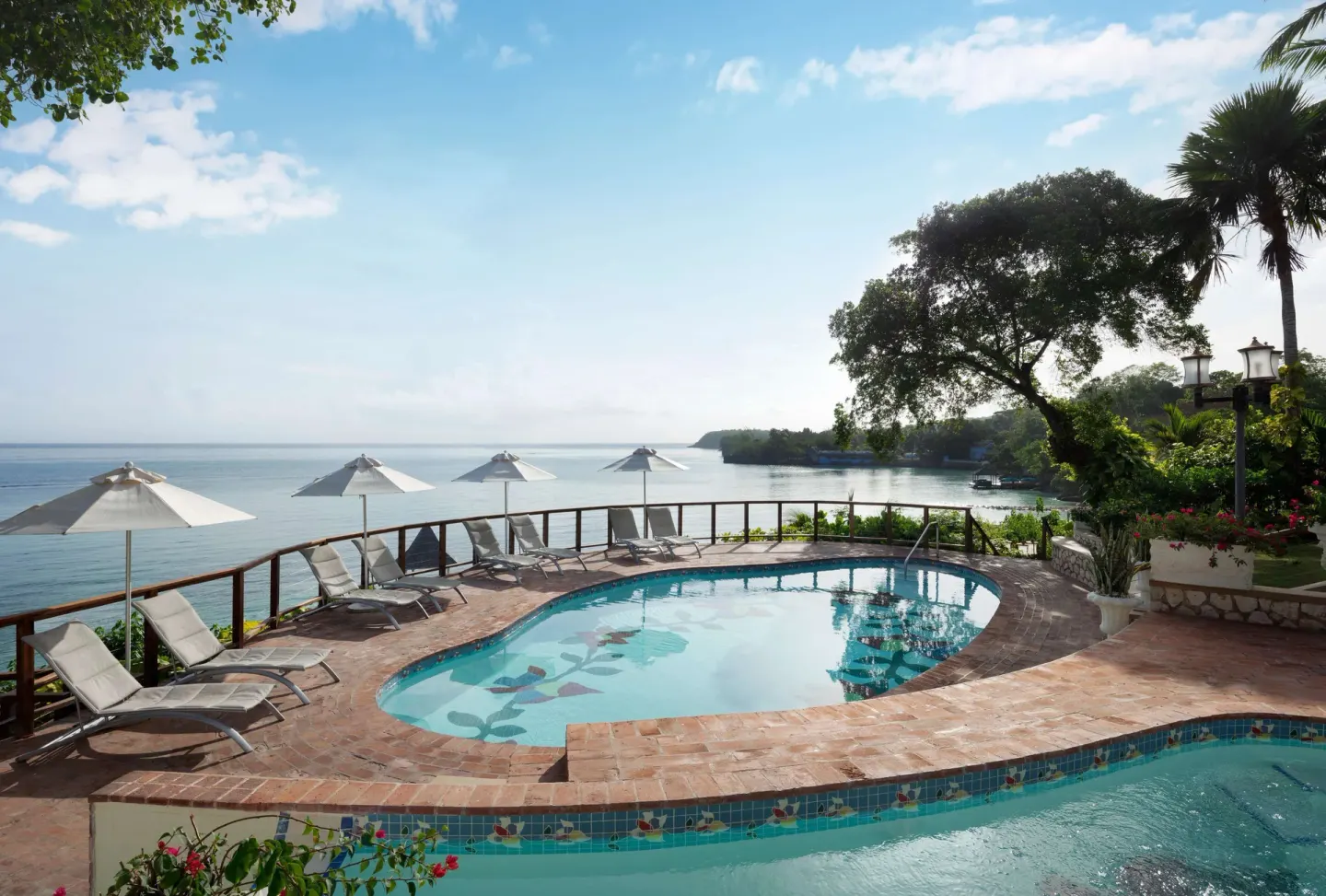 Curved pool terrace with ocean views at Sandals Royal Plantation.