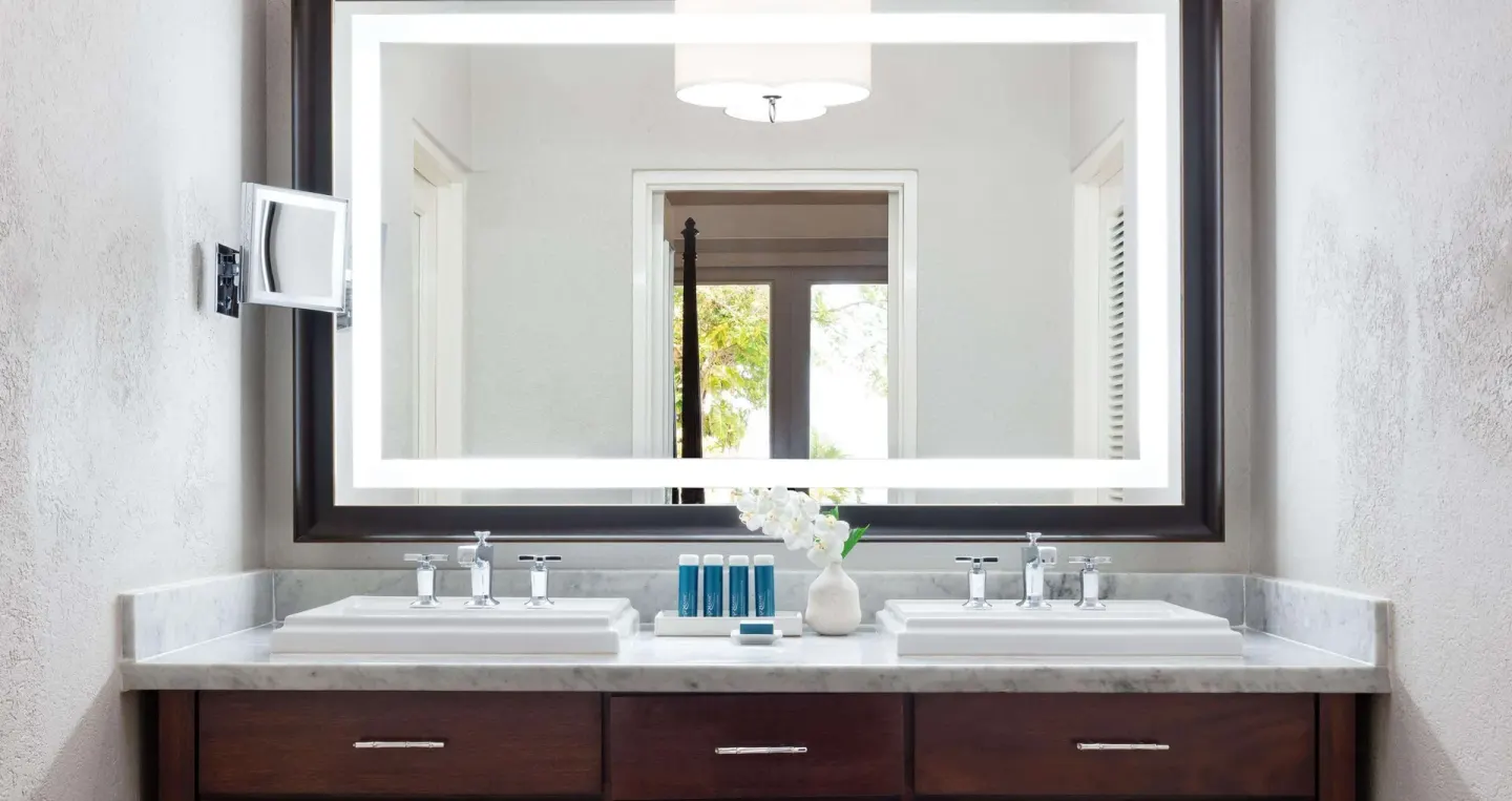 Double vanity bathroom with illuminated mirror at Sandals Royal Plantation.