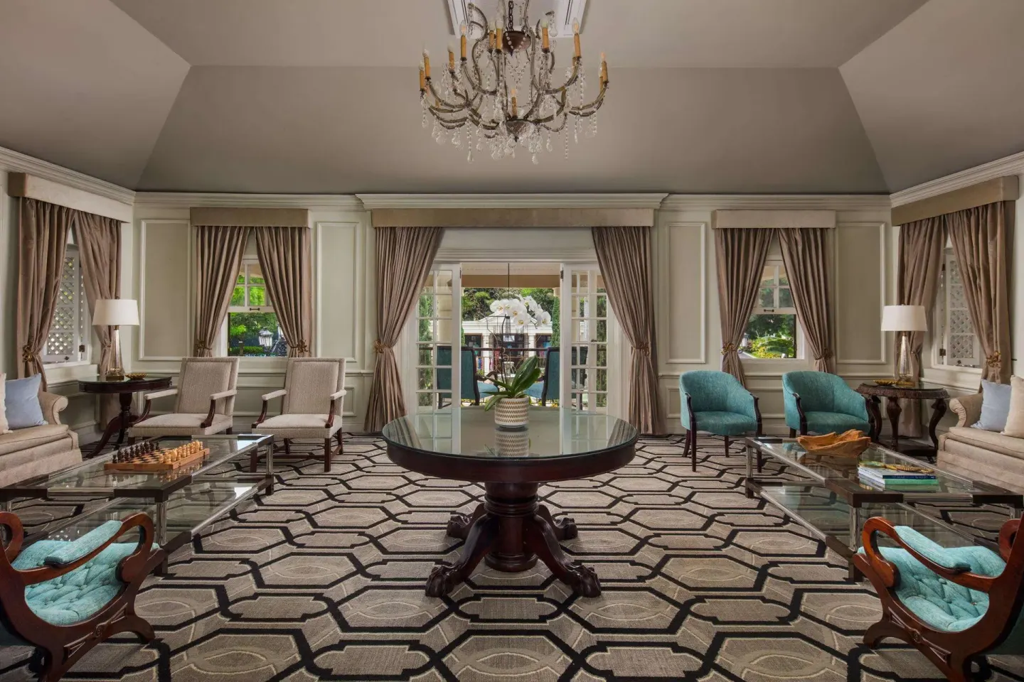 Elegant lounge with chandelier and patterned carpet at Sandals Royal Plantation.