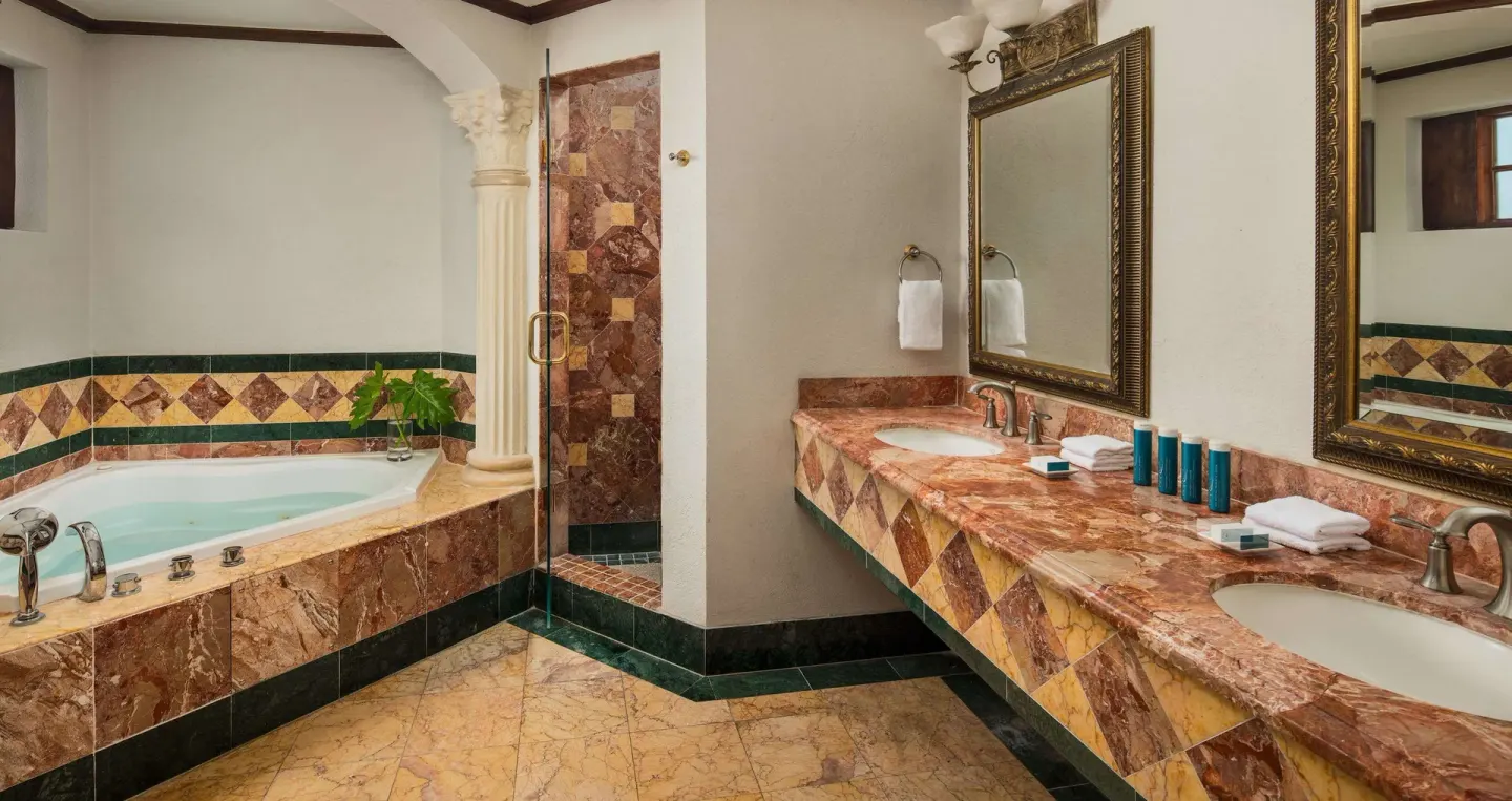 Marble bathroom with soaking tub, shower, and double vanity at Sandals Royal Plantation.