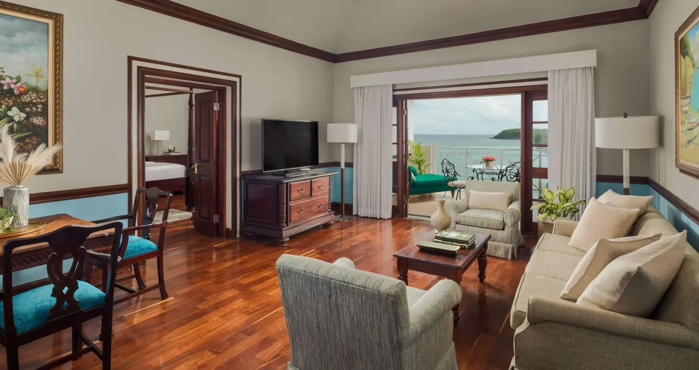 Spacious living room at Sandals Royal Plantation with balcony doors and ocean view.