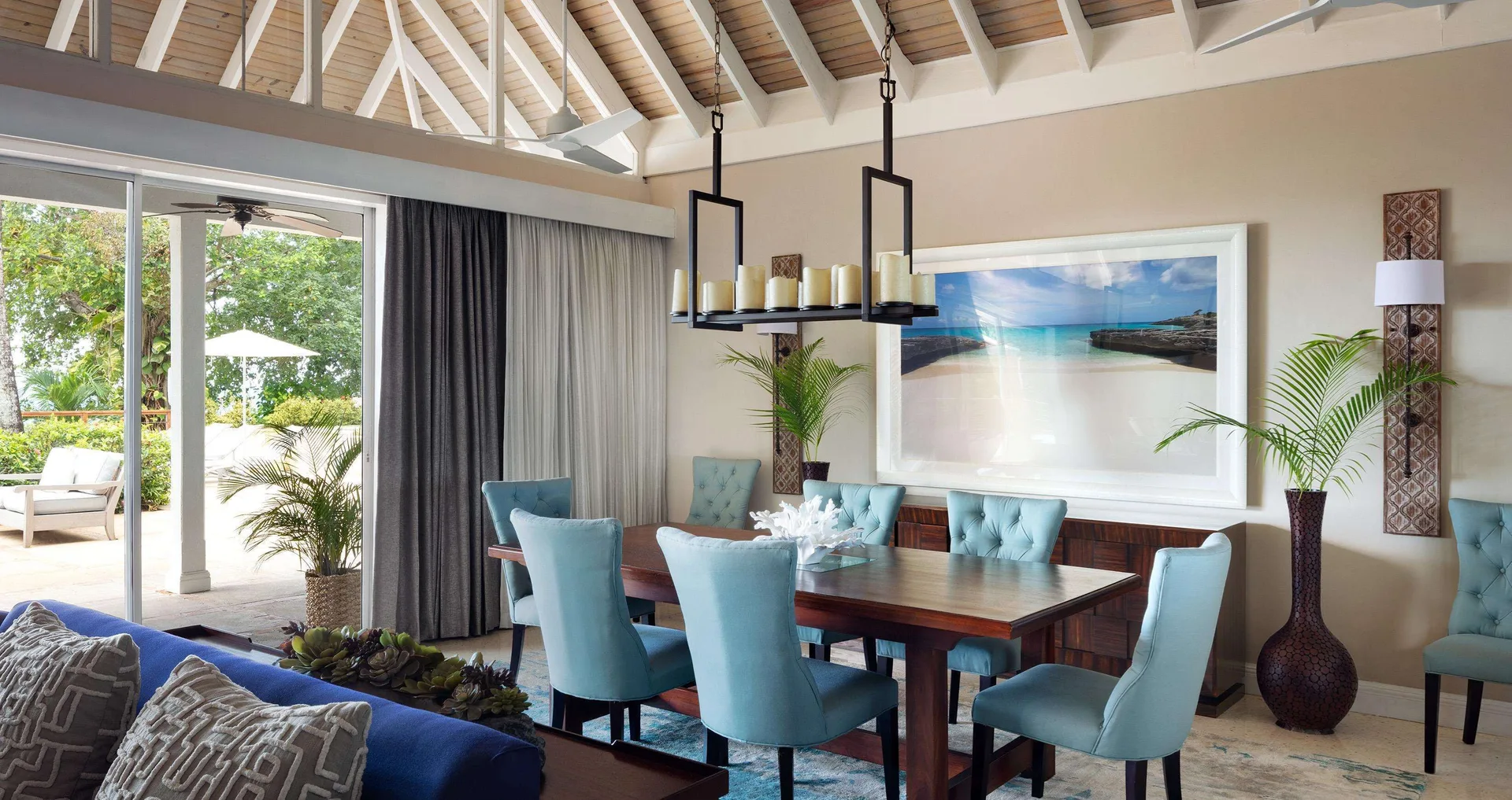 Indoor dining table with blue chairs and vaulted ceiling at Sandals Royal Plantation.