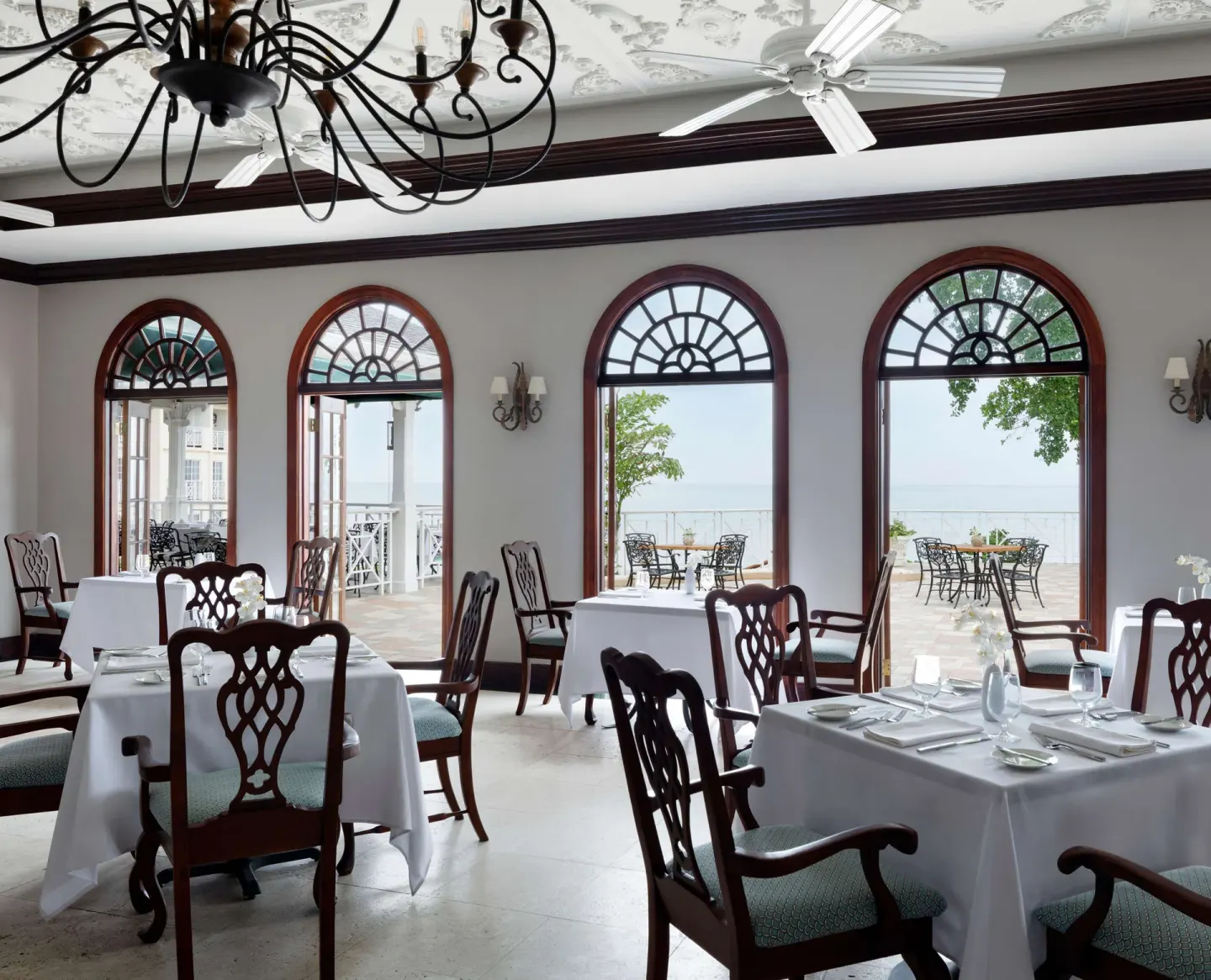 Dining room with arched ocean-view windows at Sandals Royal Plantation.