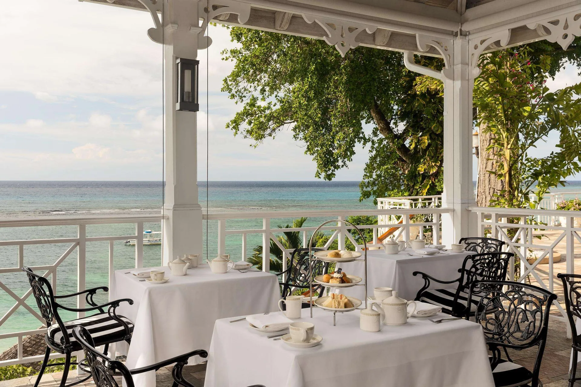 Afternoon tea tables on an oceanview terrace at Sandals Royal Plantation.