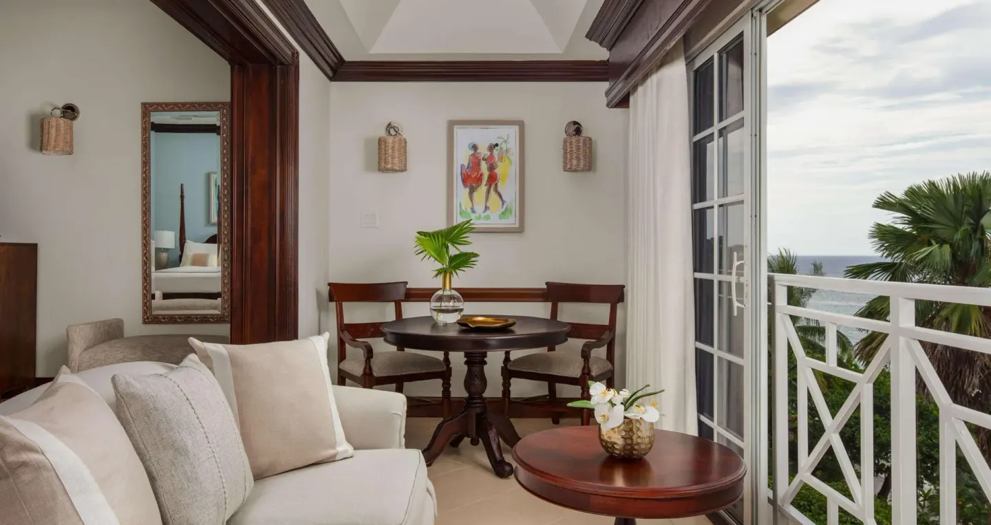 Suite sitting area with balcony and ocean beyond at Sandals Royal Plantation.