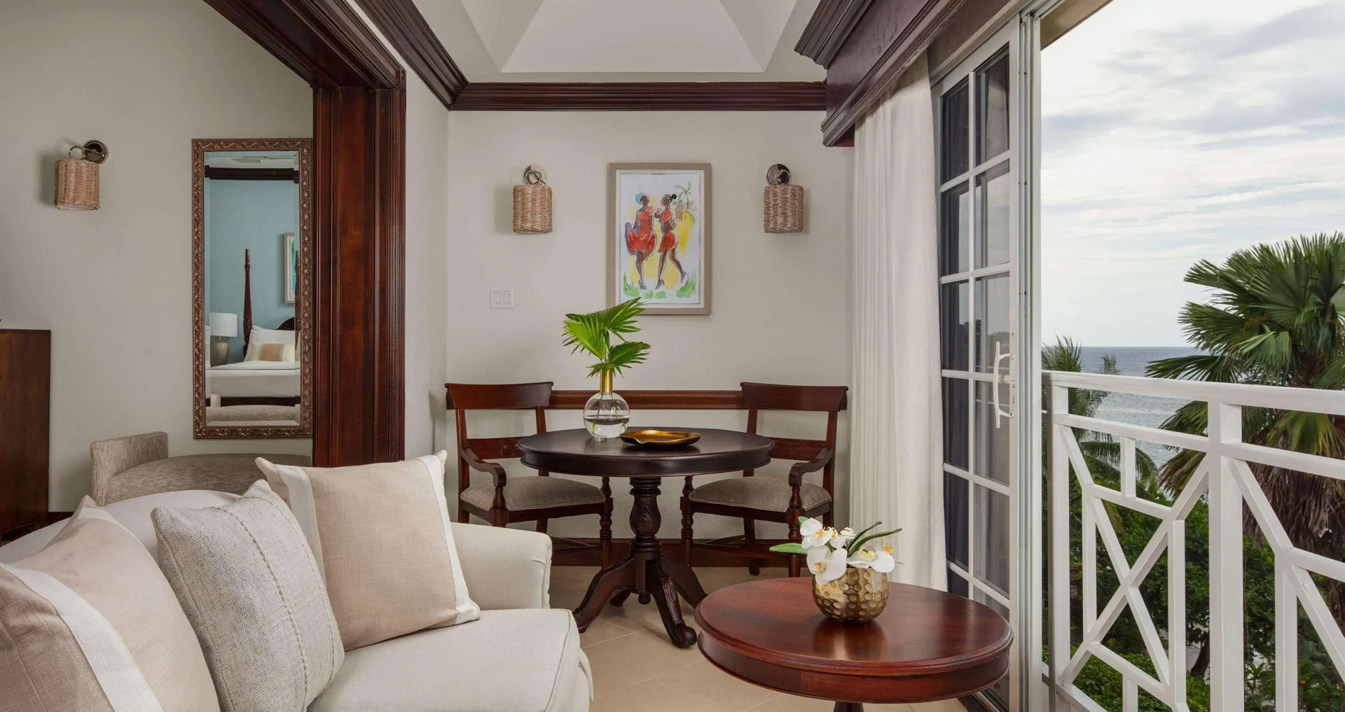 Suite sitting area with balcony and ocean beyond at Sandals Royal Plantation.