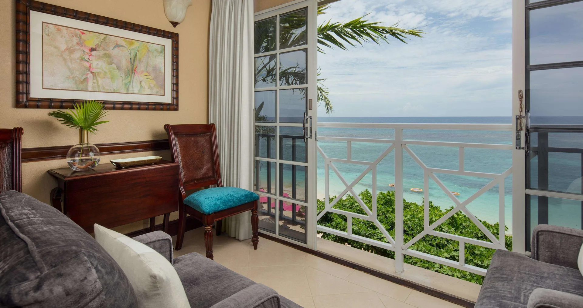Ocean-view suite sitting area and balcony doors at Sandals Royal Plantation.