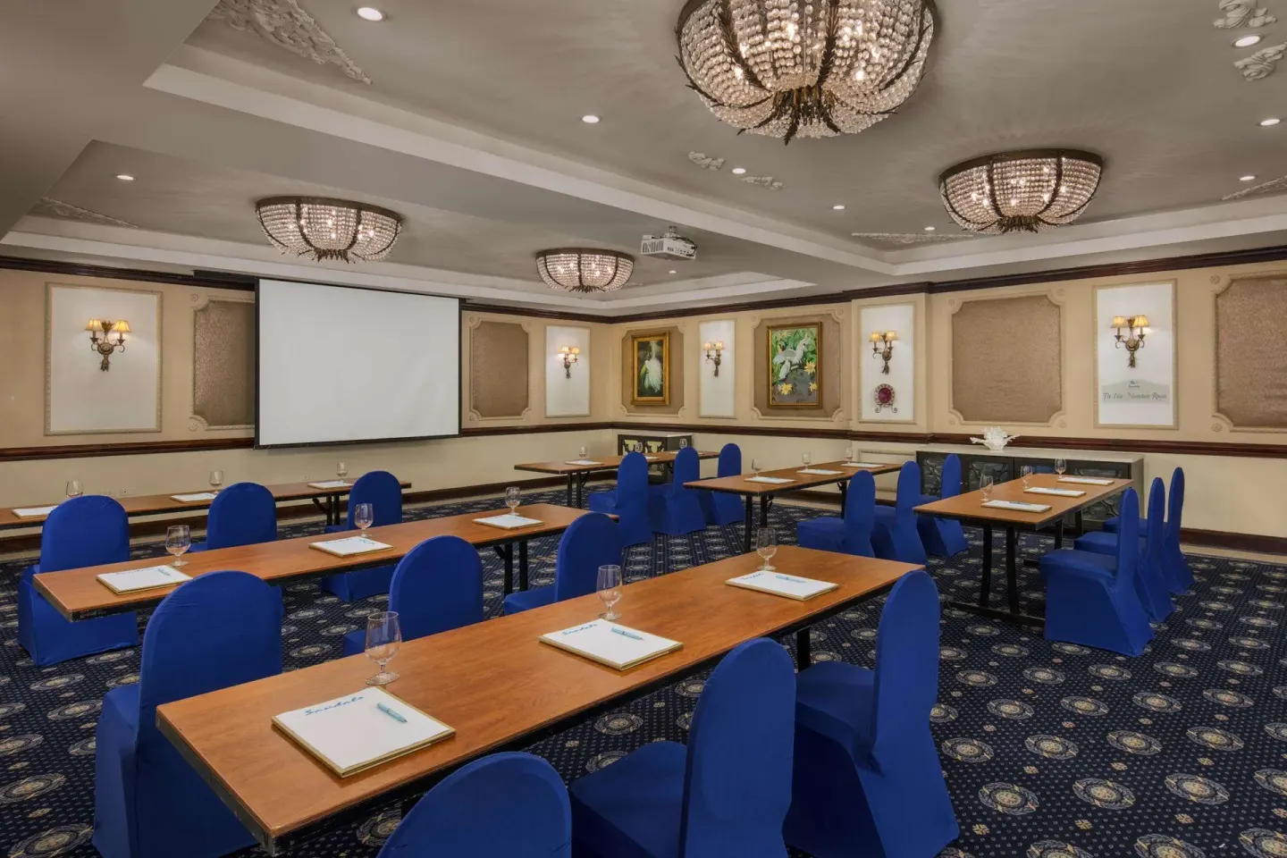 Meeting room with classroom tables and blue chairs at Sandals Royal Plantation.