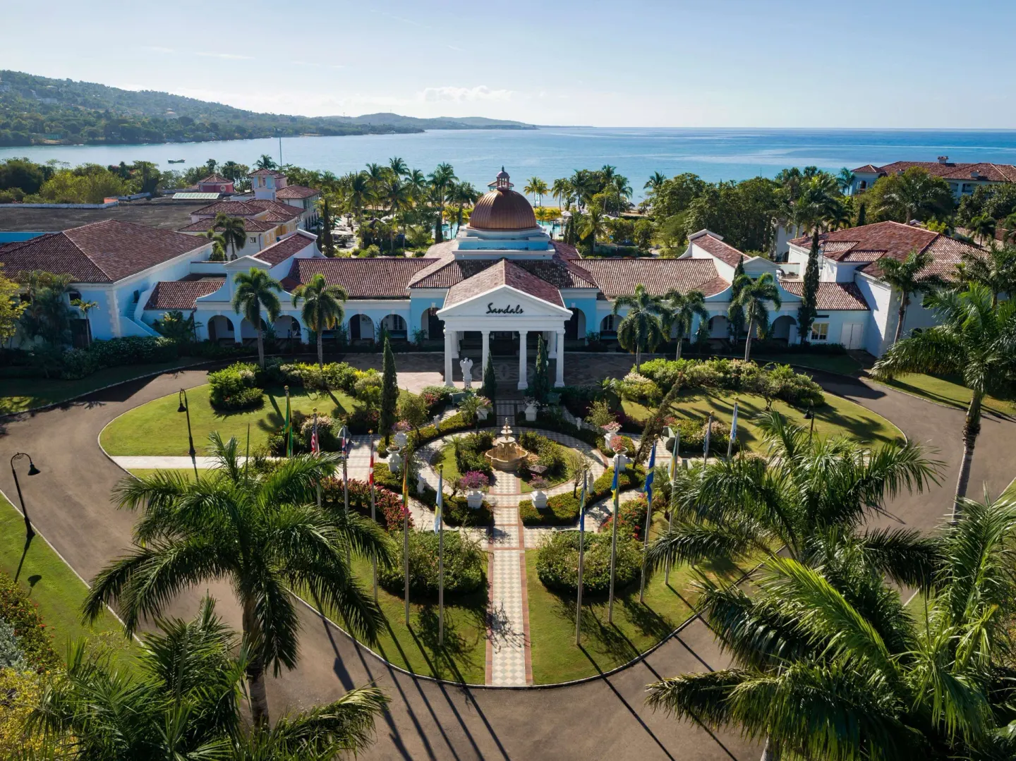 Aerial view of the front entrance, gardens, and Caribbean shoreline at Sandals South Coast.