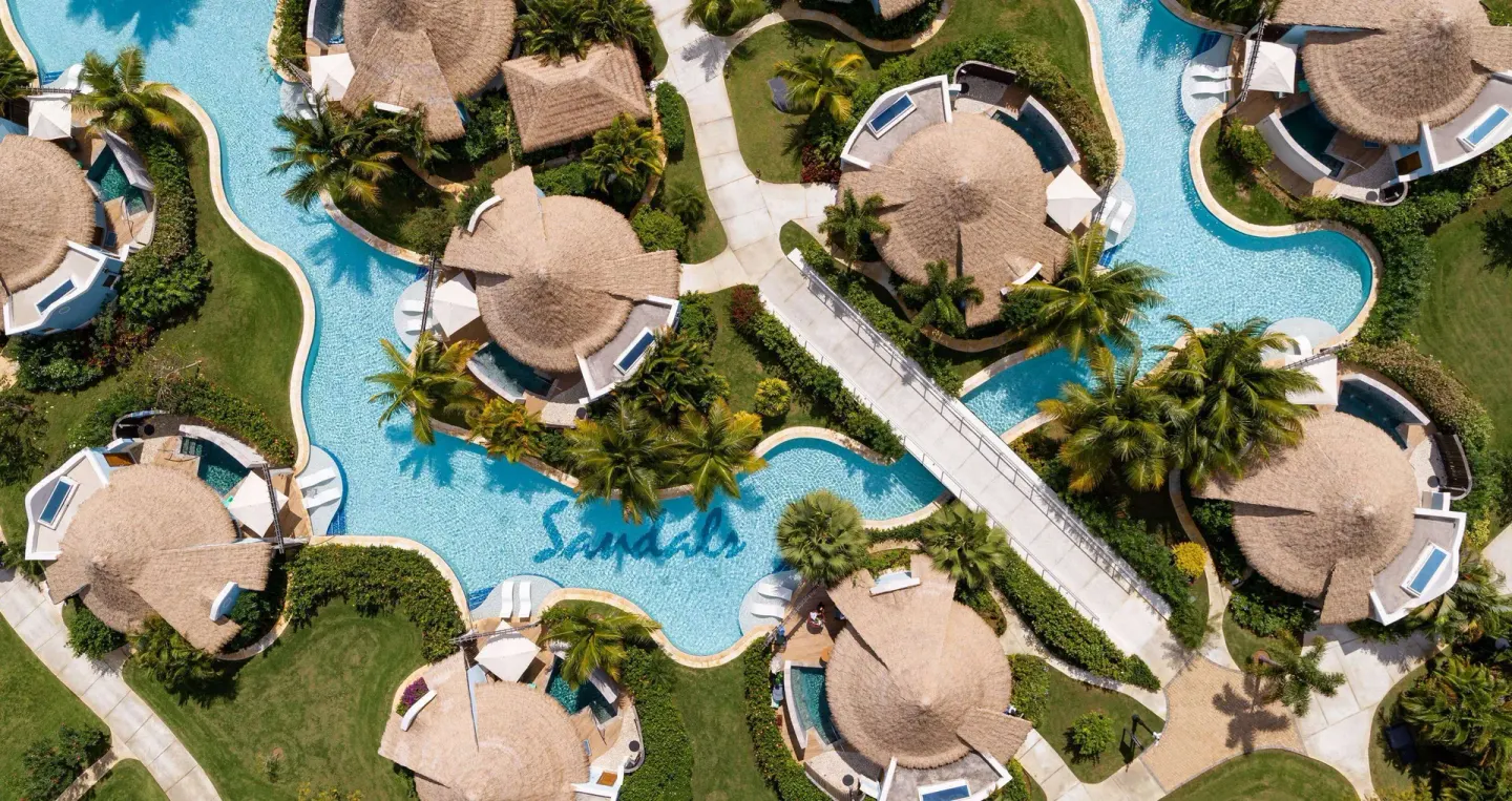 Aerial view of swim-up pools around thatched villas at Sandals South Coast.