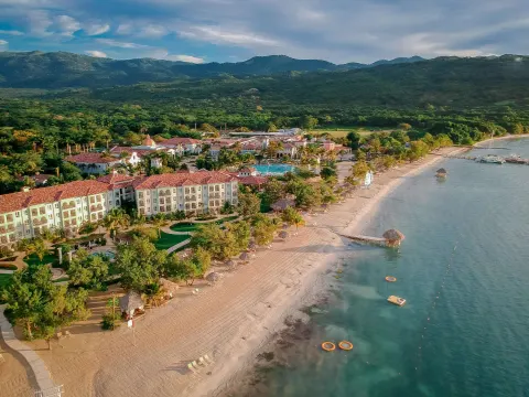 Aerial view of the beach, resort buildings, and mountains at Sandals South Coast.