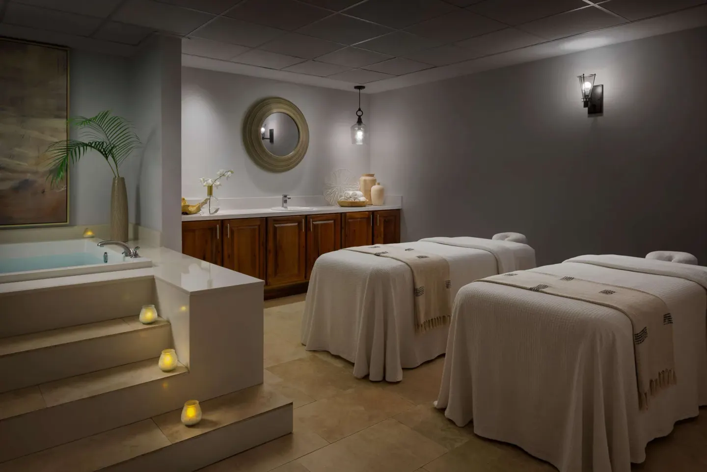 Spa treatment room with two massage tables and a soaking tub at Sandals South Coast.