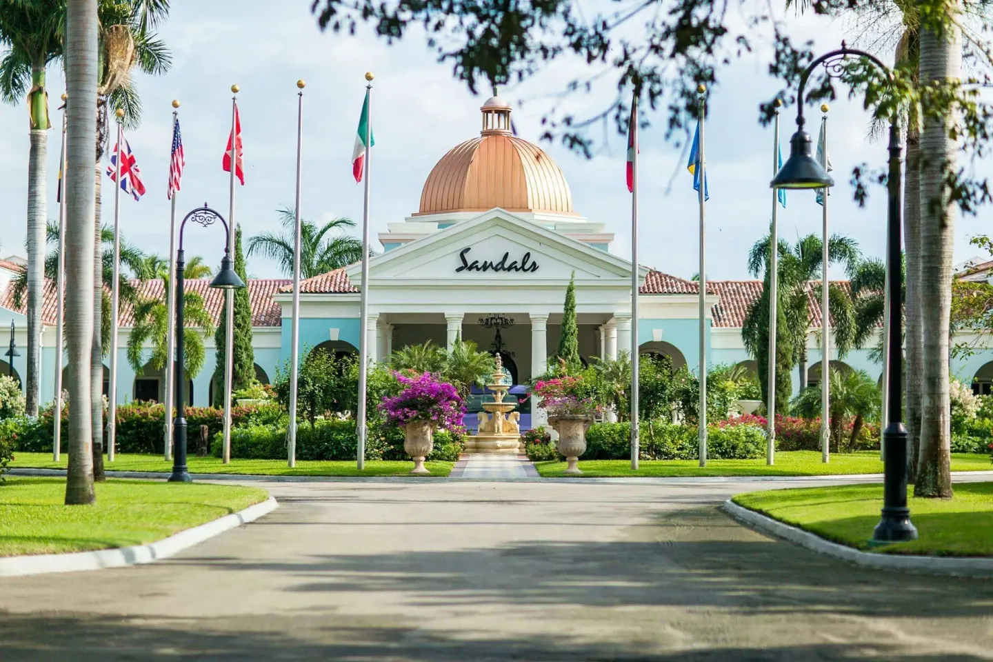 Flag-lined driveway and domed entrance building at Sandals South Coast.