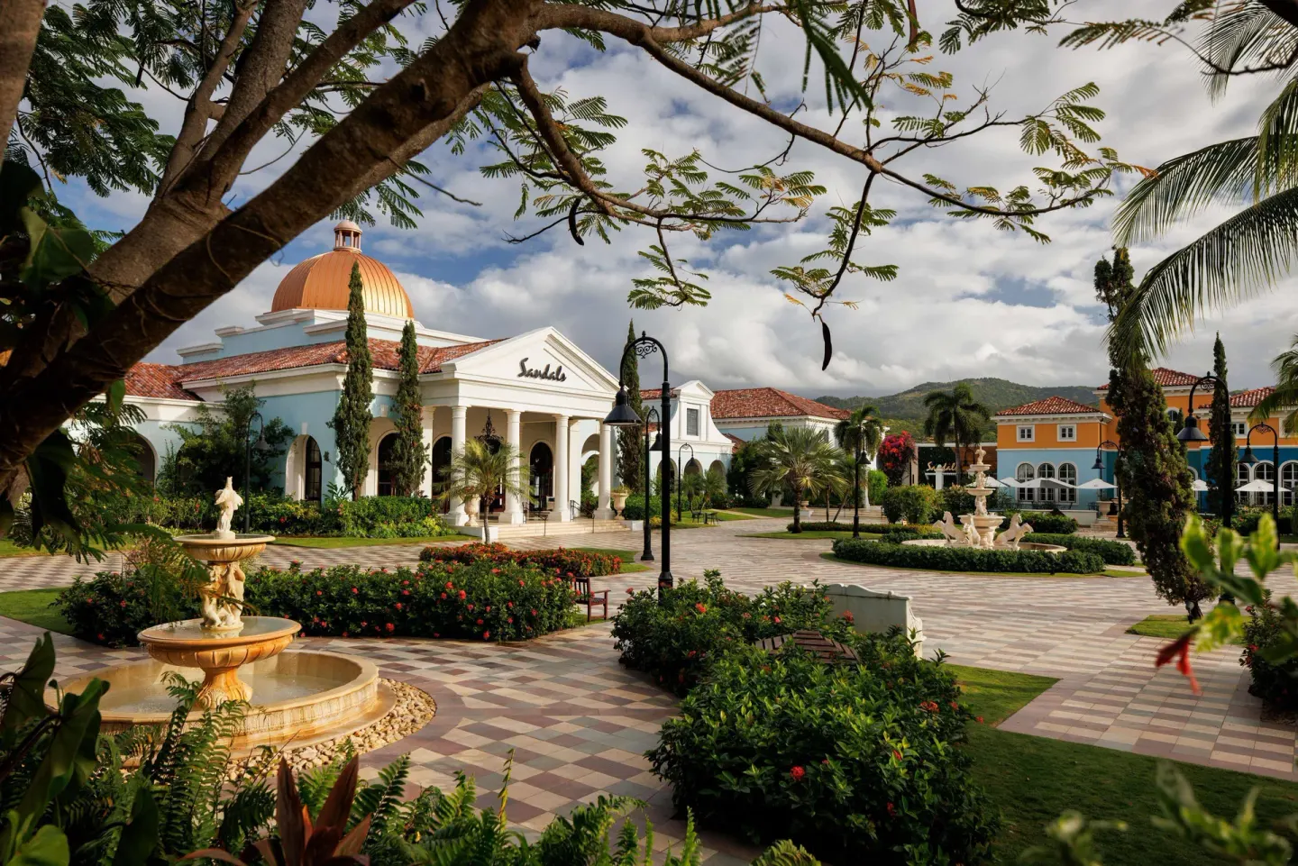 Garden courtyard with fountains and a domed building at Sandals South Coast.