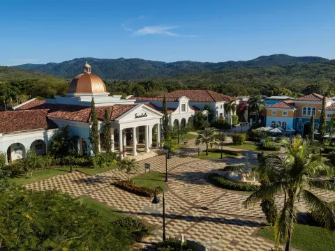 Main resort plaza and domed entrance at Sandals South Coast with mountains behind.