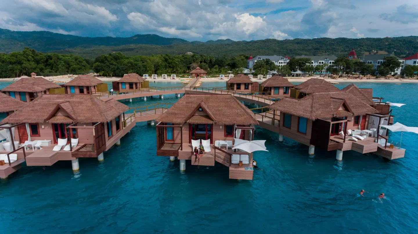 Overwater bungalows above turquoise water at Sandals South Coast.