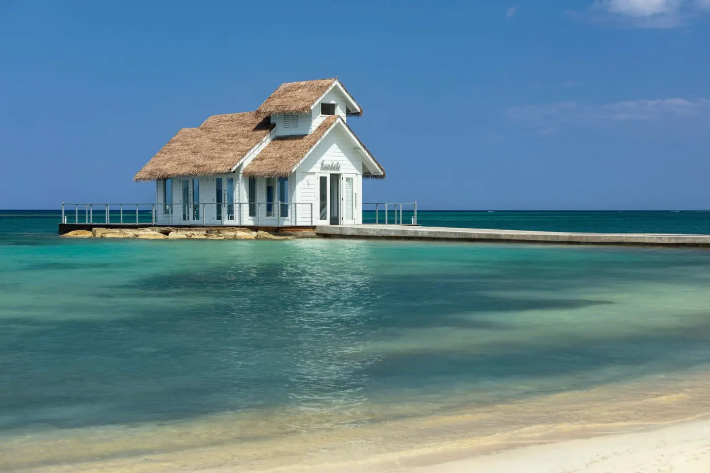White overwater chapel beside calm turquoise water at Sandals South Coast.