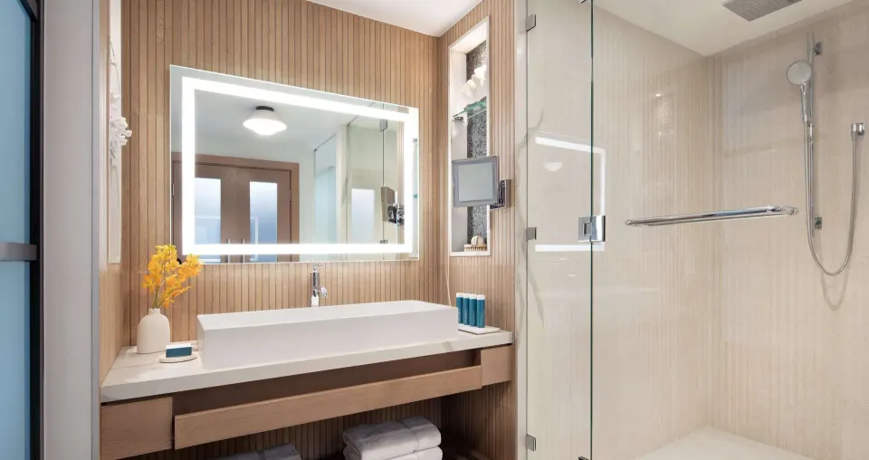 Modern suite bathroom with vanity and glass shower at Sandals South Coast.