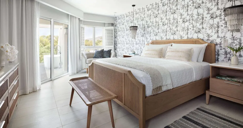 Beachfront club suite bedroom with king bed and balcony at Sandals South Coast.