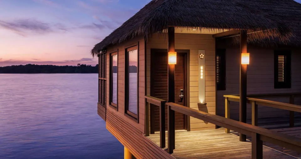 Overwater villa entrance glowing at dusk at Sandals South Coast.