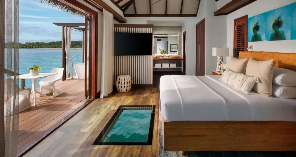 Ocean-view king bedroom in a Blue Mahoe overwater villa at Sandals South Coast.