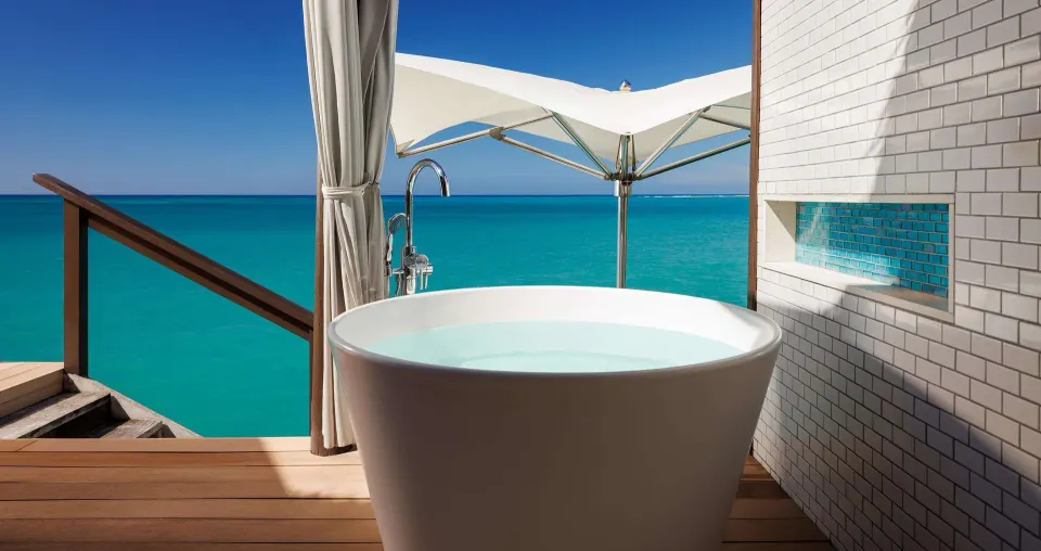 Outdoor soaking tub on an overwater villa deck at Sandals South Coast.