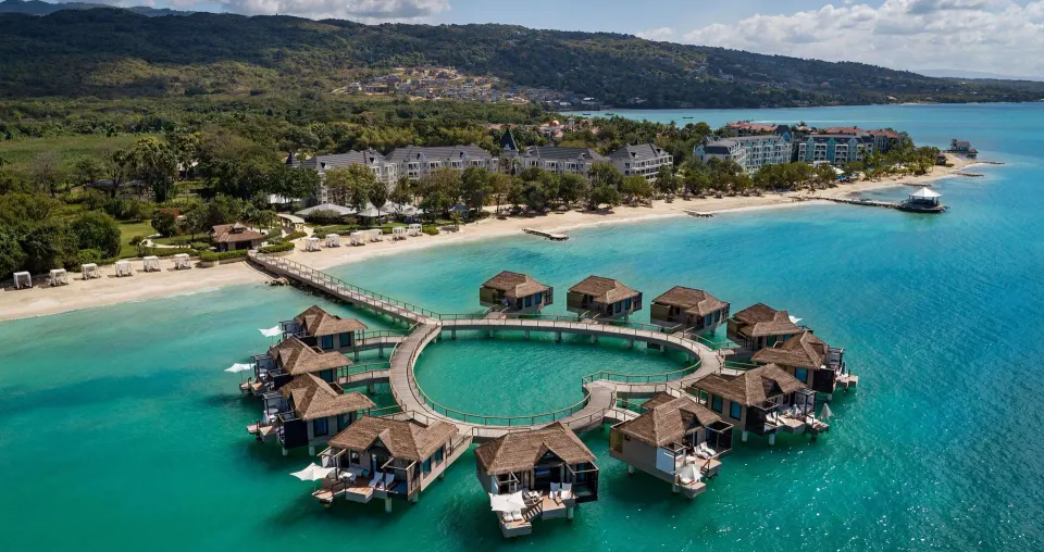 Aerial view of the overwater villas and beach at Sandals South Coast.
