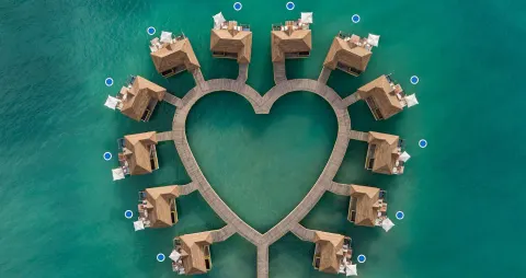 Aerial view of overwater villas in a heart shape at Sandals South Coast.