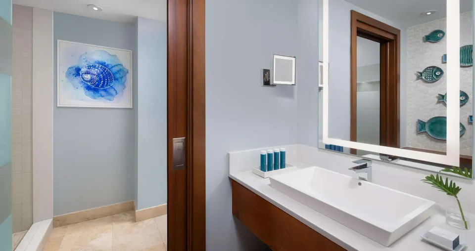 Modern bathroom vanity and walk-in shower in a honeymoon room at Sandals South Coast.