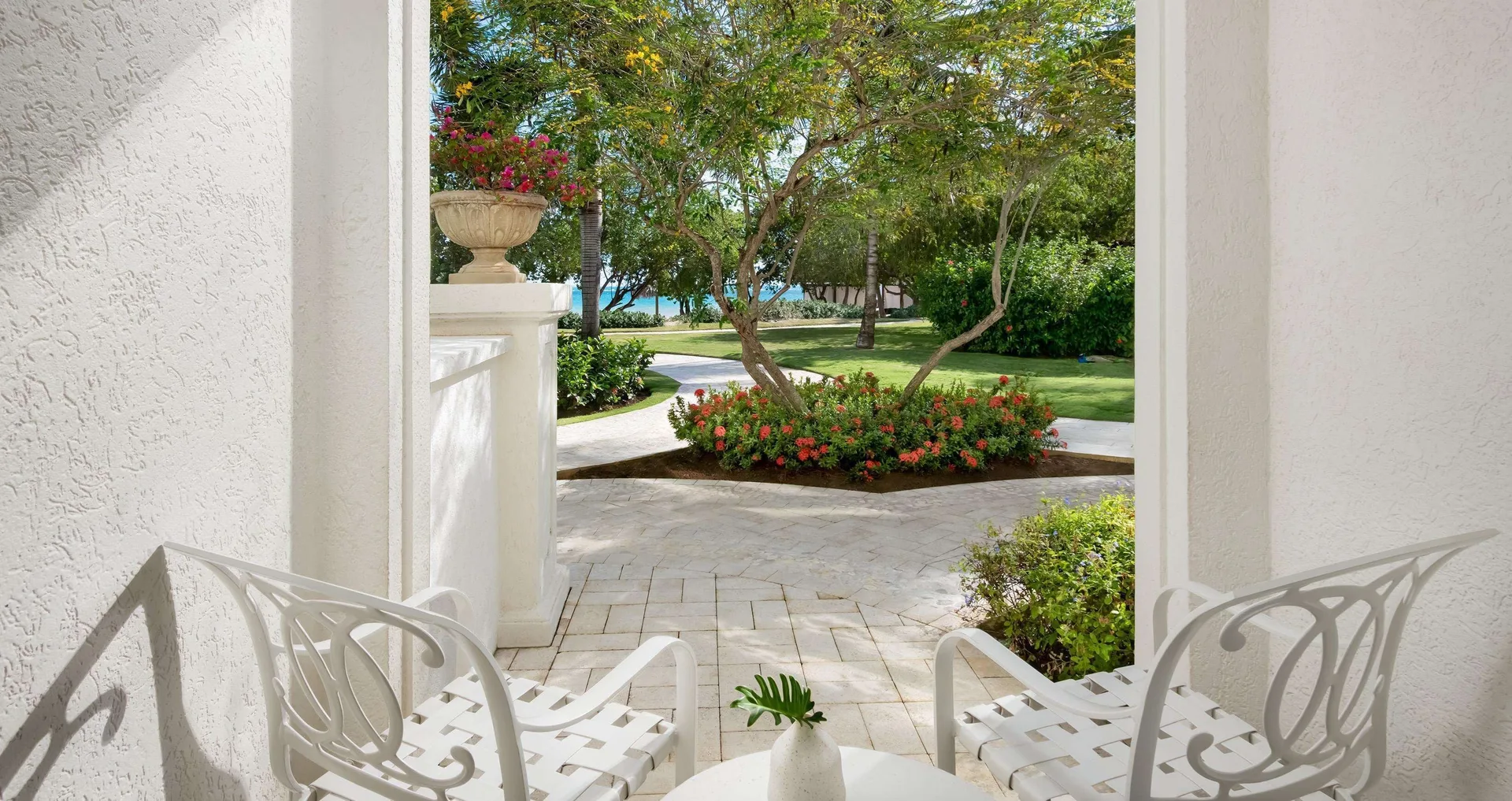 Walkout patio seating and garden view from a junior room at Sandals South Coast.