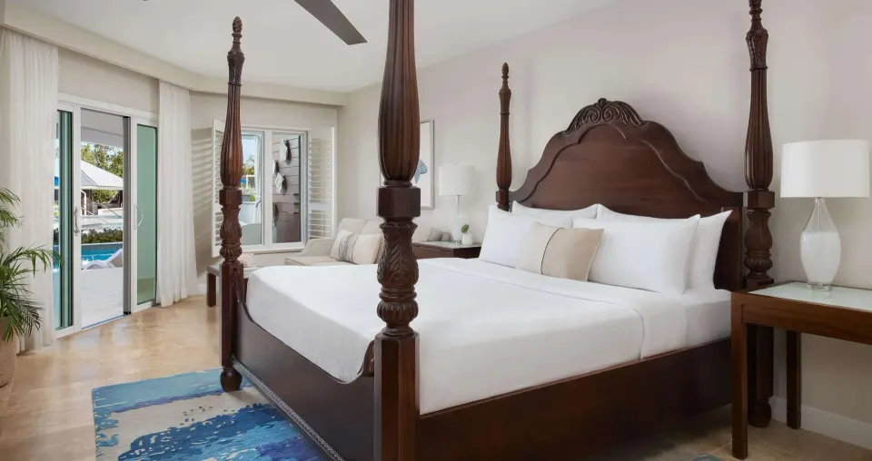 Beachfront junior suite king bed and patio doors at Sandals South Coast.