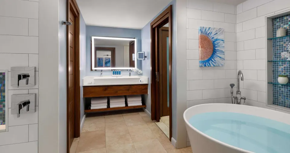 Bathroom with freestanding tub, double vanity, and tiled shower at Sandals South Coast.