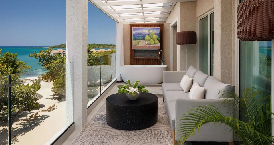 Beachfront balcony lounge with soaking tub at Sandals South Coast.