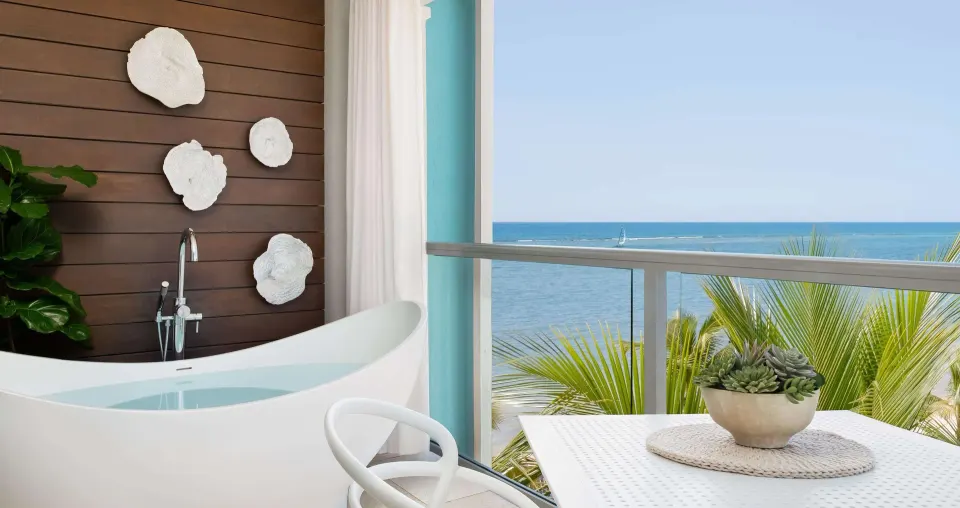 Balcony soaking tub with ocean view in a suite at Sandals South Coast.