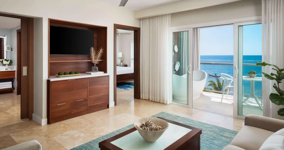 Beachfront suite living room and balcony soaking tub at Sandals South Coast.
