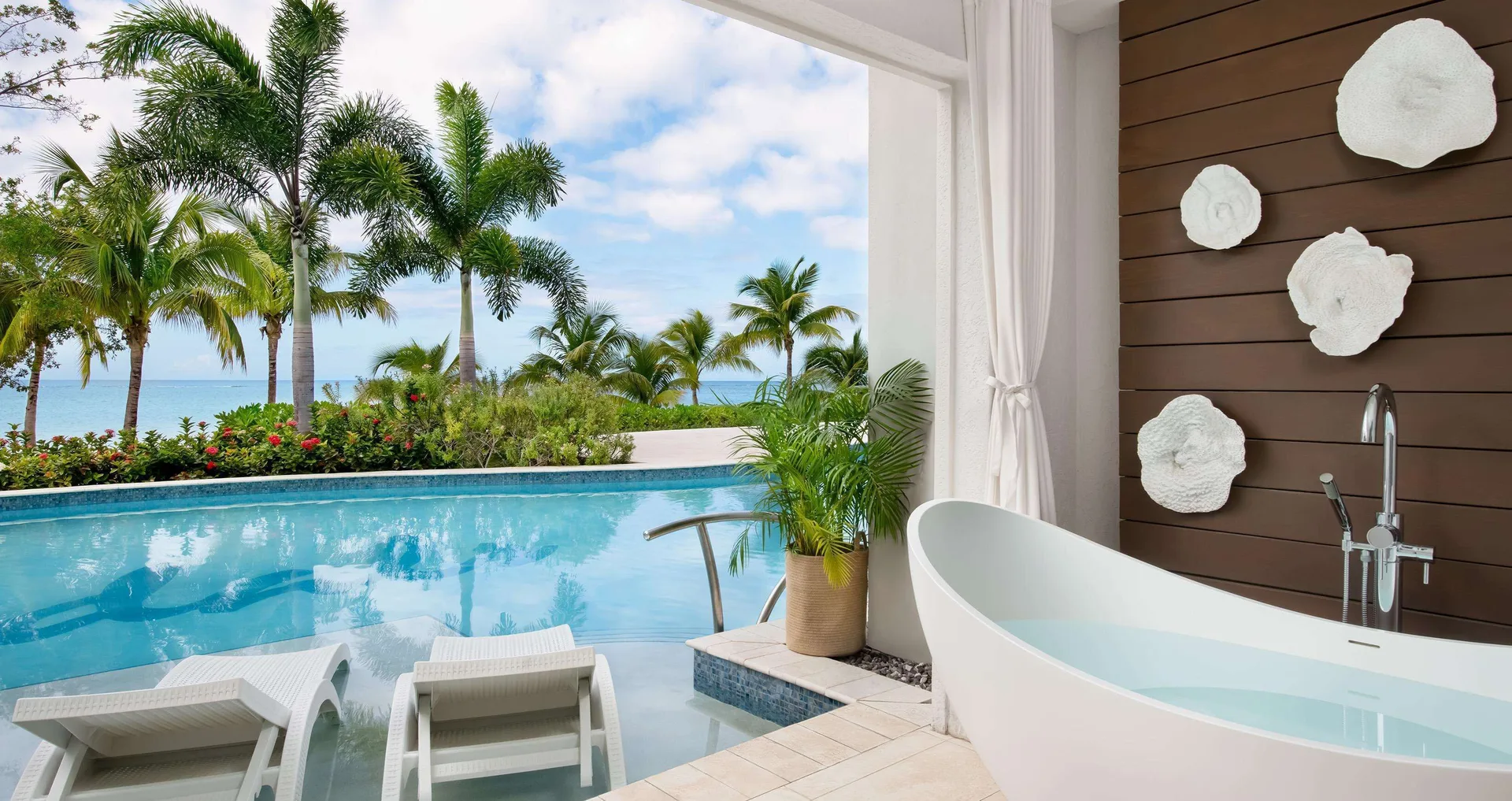 Beachfront patio soaking tub and swim-up pool at Sandals South Coast.