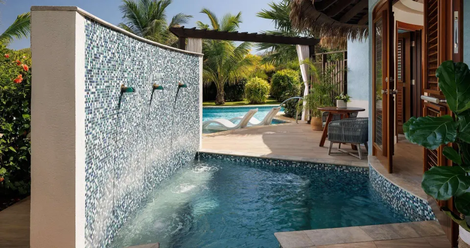 Private plunge pool with waterfall wall outside a villa at Sandals South Coast.
