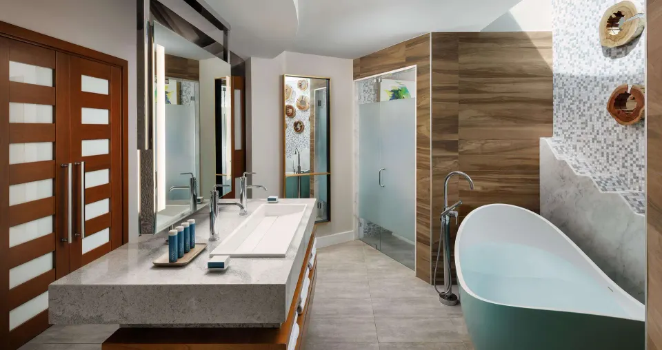 Villa bathroom with double vanity, soaking tub, and glass shower at Sandals South Coast.