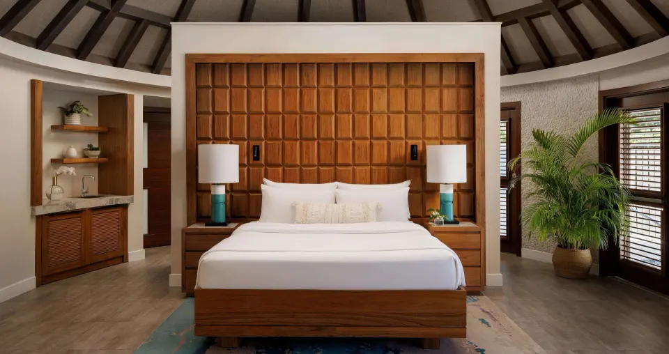 Rondoval villa king bed with wet bar and wood shutters at Sandals South Coast.