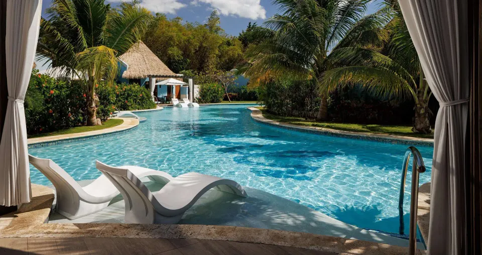 Swim-up pool with in-water loungers outside a rondoval villa at Sandals South Coast.