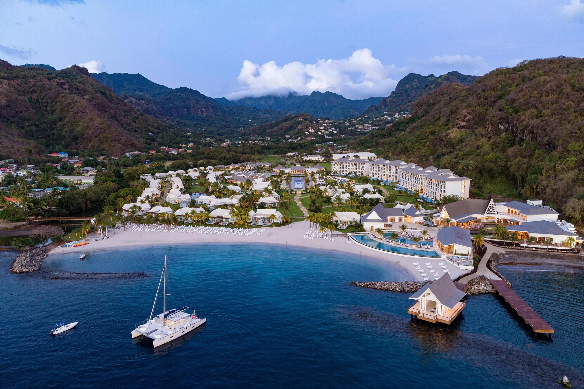 Aerial bay view of Sandals St. Vincent and the Grenadines with a catamaran offshore.