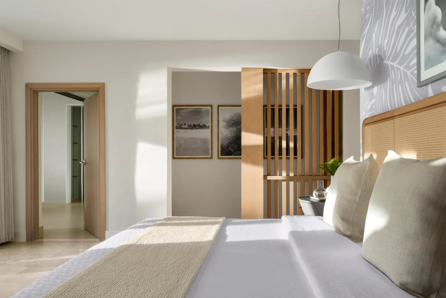 King bed facing an open doorway and wood slat divider at Sandals St. Vincent and the Grenadines.