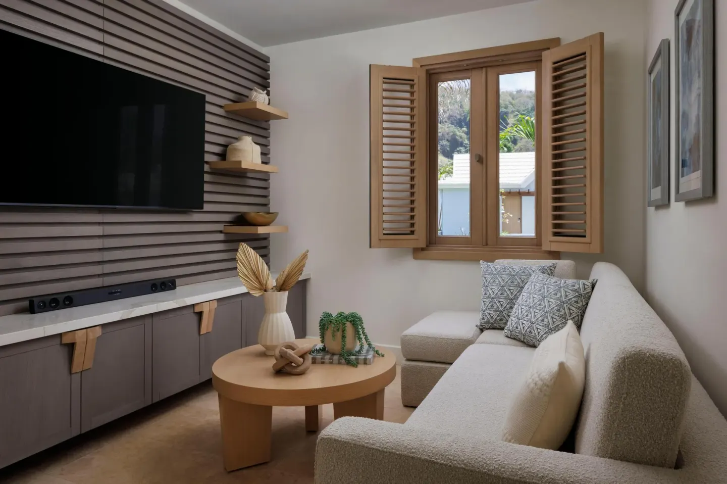 Guest suite sitting area with sofa and wall-mounted TV at Sandals St. Vincent and the Grenadines.