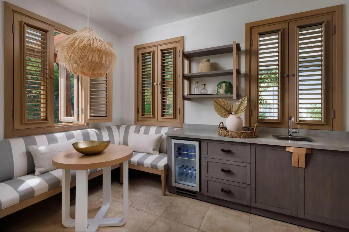 Suite dining nook with striped banquette and kitchenette at Sandals St. Vincent and the Grenadines.