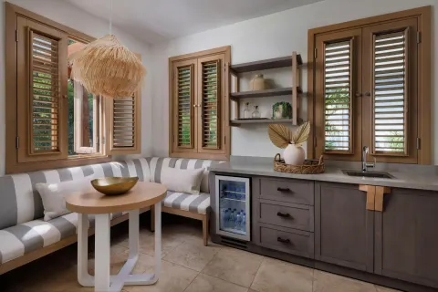 Suite dining nook with striped banquette and kitchenette at Sandals St. Vincent and the Grenadines.
