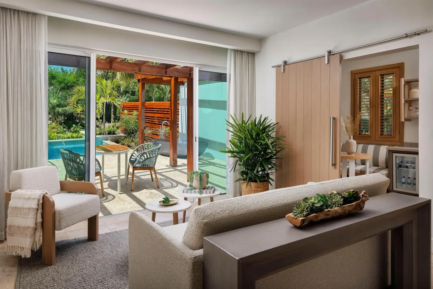 Suite living room with sofa, sliding doors, patio, and plunge pool at Sandals St. Vincent and the Grenadines.