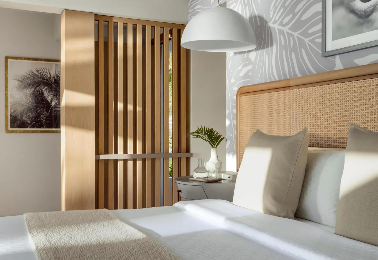 Sunlit king bed with wood slat divider at Sandals St. Vincent and the Grenadines.