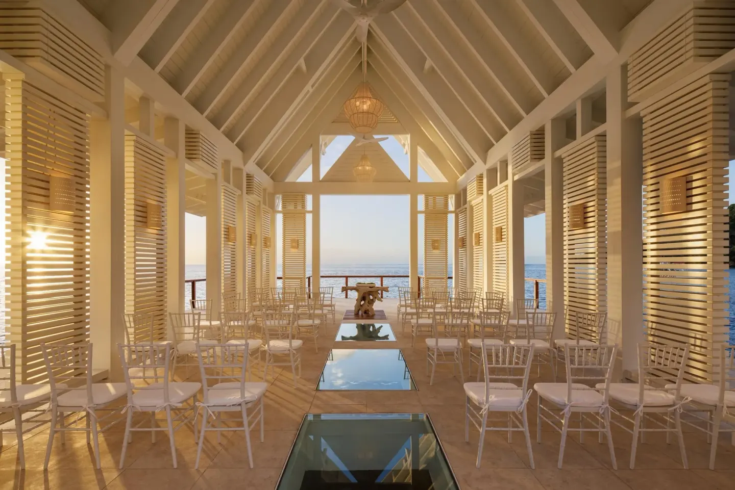 Open-air wedding chapel with white chairs and ocean views at Sandals St. Vincent and the Grenadines.