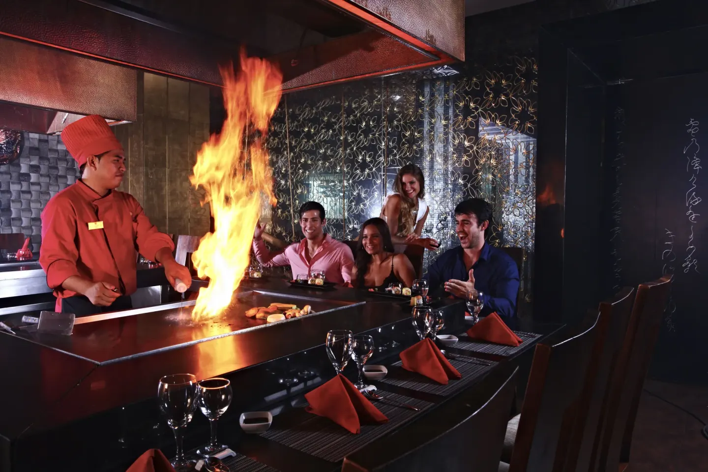Chef cooking at a teppanyaki grill for guests at Sandos Cancún.