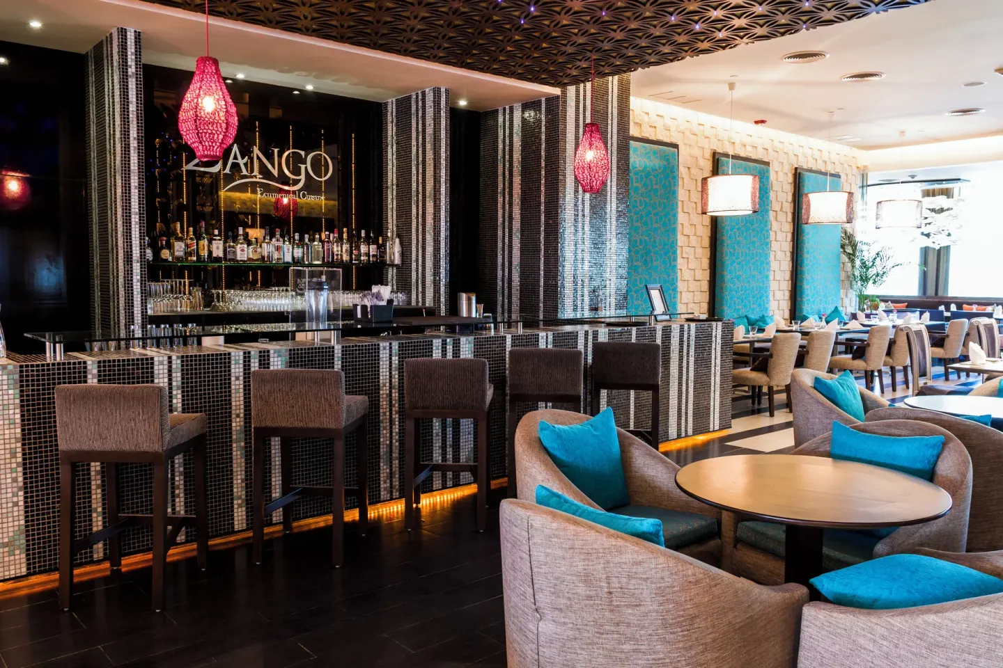 Zango bar and lounge seating with turquoise accents at Sandos Cancún.